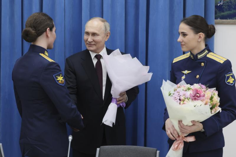 Der russische Präsident Wladimir Putin (Mitte) überreicht am Internationalen Frauentag in Krasnodar Blumen an Absolventen der nach Anatoli Serow benannten Höheren Militärfliegerschule für Piloten in Krasnodar